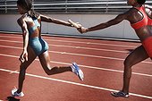Women passing baton to each other during race
