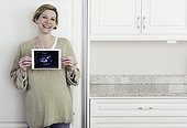 Pregnant woman holding sonogram