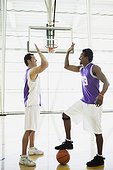 Basketball players high fiving on court
