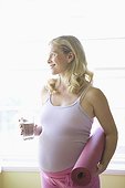 Pregnant woman with yoga mat and water