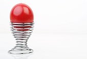 Red Easter egg in a spiral eggcup