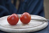 Two tomatoes on a cutting board