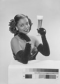 Young woman holding beer glass, smiling, portrait