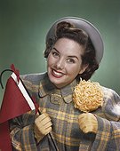 Young woman holding flag and pastry, smiling, portrait