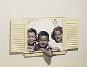 Children looking through window, smiling, portrait