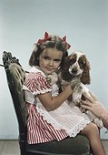 Girl sitting with dog on chair, smiling