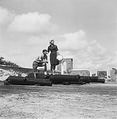Young couple standing on cannon, smiling