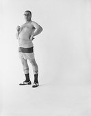 Man in shorts holding cigar against white background, portrait