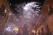 Oaxaca, Mexico.. A woman lights firecrackers in celebration.