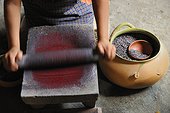 Oaxaca, Mexico.. A woman rolls dye to make candles.