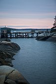 Spruce Head Island, Maine, United States of America.. A fishing dock crosses an inlet to a harbor at sunrise in Maine.