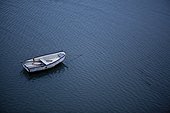 Spruce Head Island, Maine, United States of America.. An anchored row boat floats in in calm waters in Maine.