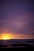 Spruce Head Island, Maine, United States of America.. The summer sun rises over islands in a Maine harbor.