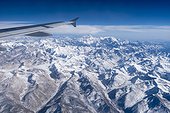 Lhasa, Tibet, China.. A jet in flight above the mountains of the high Tibet plateau.