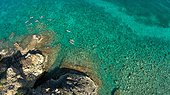 Ten people swim around an island.. British Virgin Islands.