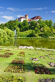 Germany, Lower Saxony, Bad Iburg, Schloss Bad Iburg seen from Charlottensee lake with garden in the foreground.