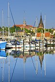 Germany, Schleswig-Holstein, Flensburg, im jaich yachthafen and yachts in the foreground with Flensburg old town and Sankt Marien kirche in the background.