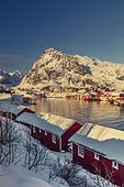 Norway, Nordland, Lofoten Islands, Scandinavia, Moskenesøya, Traditional village of Sorvagen in Lofoten Islands with its typical fishermen houses called Rorbuer on a winter morning with the mountains in the background covered with snow
