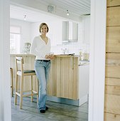 Portrait of smiling woman standing in kitchen