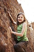 Portrait of smiling girl climbing rock