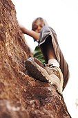 Low angle view of girl climbing rock
