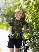 Boy walking with bicycle