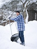 Man removing snow with large shovel from back yard