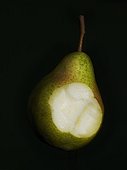Bite in pear on black background, studio shot