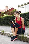 Woman in workout clothes holding mobile phone