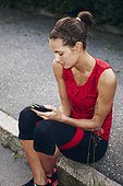 Woman in workout clothes holding mobile phone