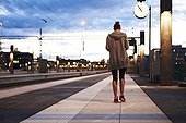 Woman in workout clothes walking away at train station
