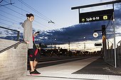 Woman in workout clothes waiting for a train