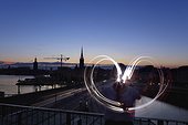 Person drawing light heart shape in air, Stockholm, Sweden