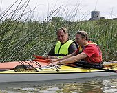 Two men in kayak looking at a map