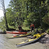 Two men with kayaks at a beach