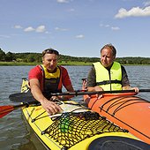 Two men in kayak looking on a map