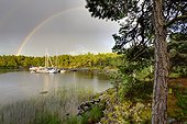 Rainbow over small bay with sailing boats moored in