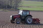Farmer in tractor plowing field
