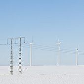 Wind turbines and electricity pylon in winter landscape