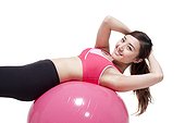 Young woman doing sit-ups on a fitness ball