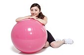 Young woman leaning on a fitness ball