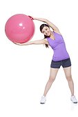 Young woman stretching with fitness ball