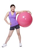 Young woman posing and holding fitness ball
