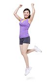 Young woman jumping with arms raised in excitement