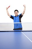 Table tennis player cheers with arms raised