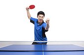 Table tennis player cheers with fists balled