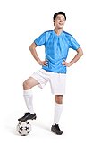 Soccer player with hands on hips stepping on the ball