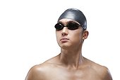 Swimmer with swimcap and goggles looking on