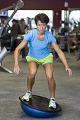 Woman using Balance Ball in Gym