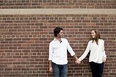 Portrait of Young Couple Standing in front of Brick Wall
